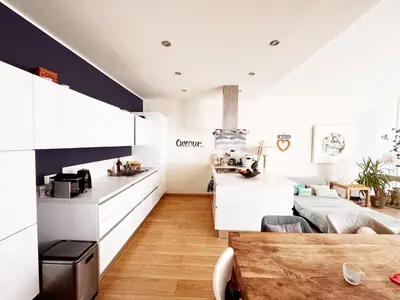 a kitchen and living room with white cabinets and a table at Blue dream and zen Holidays in Nice