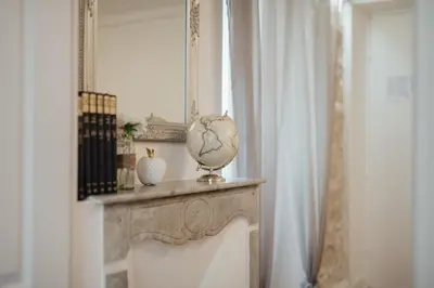 a mirror and a vase on a mantle in a room at Le Chic, appartement plein centre avec Climatisation in Nice