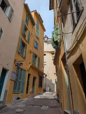 an alley in an old town with yellow buildings at Studio calme & climatisé - Quartier du Vieux-Nice animé proche plages & restos in Nice