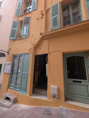 an orange building with green doors and windows at Studio calme & climatisé - Quartier du Vieux-Nice animé proche plages & restos in Nice