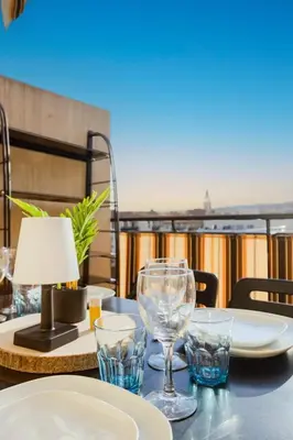 a table with glasses and a lamp on a balcony at Studio Terrace AC Lift - Old town | By Airnest in Nice