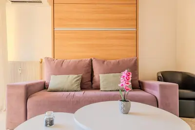 a living room with a pink couch and a table at Studio Terrace AC Lift - Old town | By Airnest in Nice