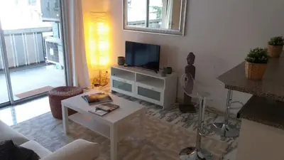 a living room with a tv and a table at Baquis in Nice