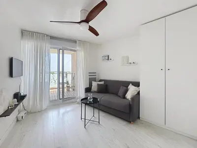 a living room with a couch and a ceiling fan at Studio Neuf avec Terrasse et Aperçu Mer in Nice