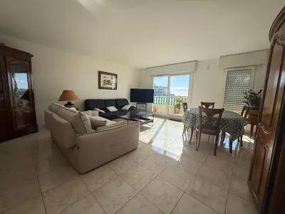 a living room with a couch and a table at 3 Pieces st laurent du Var in Saint-Laurent-du-Var