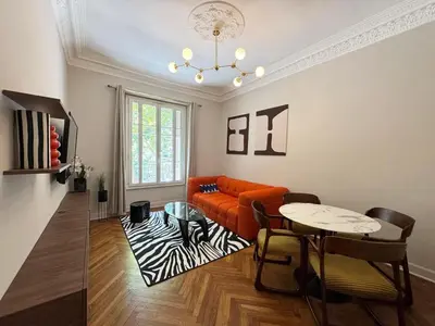 a living room with an orange couch and a table at Magnifique appartement dans palais Niçois in Nice