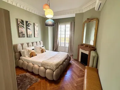 a bedroom with a large bed and a mirror at Magnifique appartement dans palais Niçois in Nice
