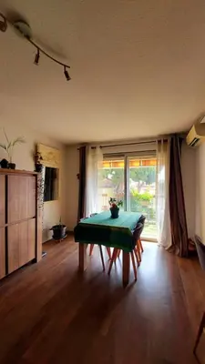 a living room with a green table and a window at Apartment with balcony 5 minutes walk from the sea in Cagnes-sur-Mer
