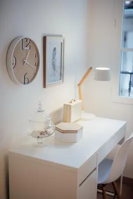 a white desk with a clock and a table with chairs at L'Authentic, charme dans la vieille ville avec climatisation in Nice