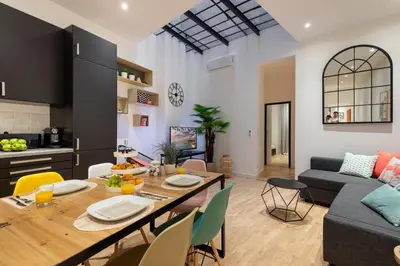a kitchen and living room with a table and a couch at L'Atelier, loft confortable dans la vieille ville, avec climatisation in Nice