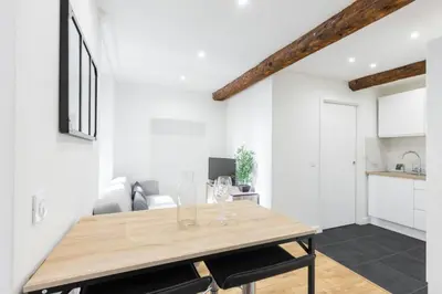 a dining room with white walls and a wooden table at Charmant petit 2 pieces dans la vieille ville - B in Nice
