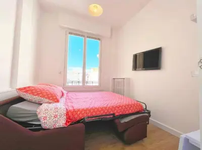 a bedroom with a bed and a tv on a wall at Lumineux studio proche Jean Medecin in Nice
