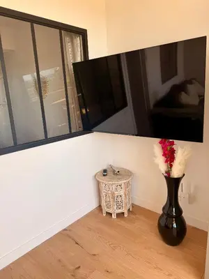 a vase with flowers in a room with a mirror at Votre grand COCON Niçois Appart Vue Mer in Nice