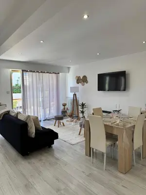 a living room with a black couch and a table at Charmant 2pcs - 5min des plages in Cagnes-sur-Mer