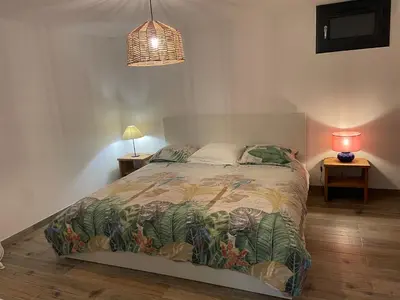 a bedroom with a bed and a lamp on a table at Le petit Baou in Saint-Jeannet