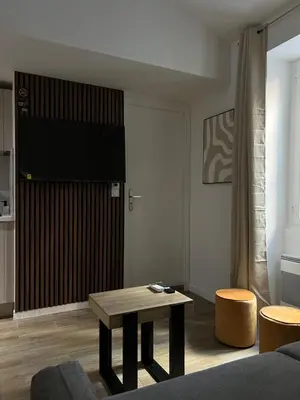 a living room with a table and a tv at Appartement confort au cœur de Nice in Nice