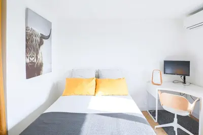 a bedroom with a bed and a desk with a monitor at Villa Bleu Azur - Élégance Privée avec Vue Mer & Montagne in Cagnes-sur-Mer