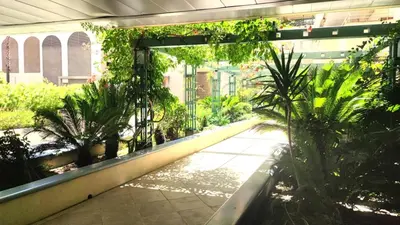 a walkway in a building with trees and plants at Superbe appartement carre d or in Nice