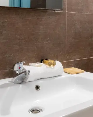 a bathroom sink with a towel and a faucet at 2 pièces - Clim - tram à 5' centre à 15' in Nice