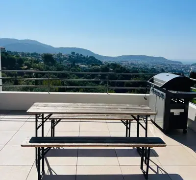 a picnic table on a balcony with a grill at Contemporary Villa with Sea View, Infinity Swimming pool, Gym , Cinema room,Lift in Nice