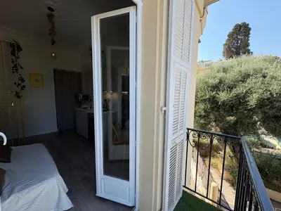an open door to a balcony with a bed on a porch at Studio de Charme à Nice - Idéal télétravail - Balcon - Plage à 300m in Nice