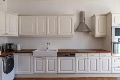 a white kitchen with white cabinets and a sink at Grand appartement climatisé centre ville Nice in Nice