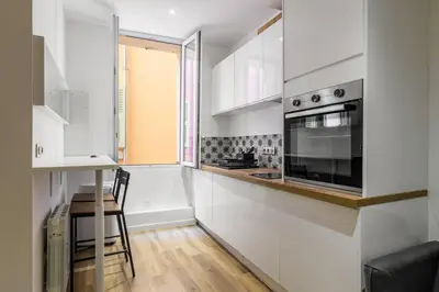 a kitchen with white cabinets and a window at Appartement cosy au coeur de la vieille ville in Nice