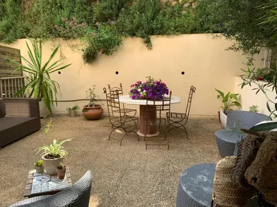 a patio with a table and chairs and plants at L'Échappée Belle in Nice