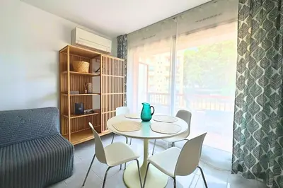 a living room with a table and chairs and a couch at Magnifique Studio Le Renoir proche mer in Nice