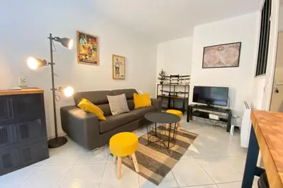 a living room with a couch and a table and a television at Beautiful apartment on the heights of Nice - Parking in Nice