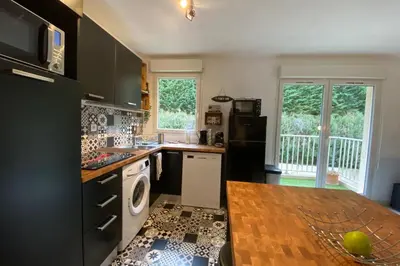 a kitchen with black and white appliances and a table at Beautiful apartment on the heights of Nice - Parking in Nice
