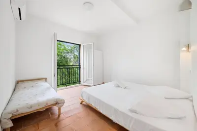 a white bedroom with a bed and a window at La Quiétude - Spacious - Magnificent mountain view - AC - Jacuzzi in Aspremont