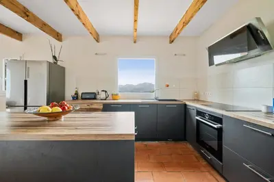 a kitchen with a bowl of fruit on a counter at La Quiétude - Spacious - Magnificent mountain view - AC - Jacuzzi in Aspremont
