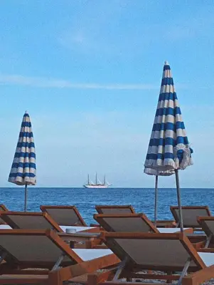 a group of lounge chairs and umbrellas on a beach at Bohemian style and luminous balcony in Nice