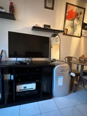 a flat screen tv sitting on top of a entertainment center at Studio magnan grand balcon in Nice