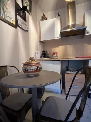 a small kitchen with a table with a bowl on it at Studio magnan grand balcon in Nice
