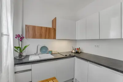 a kitchen with white cabinets and a sink at Nice design, calme & gare à 5 min à pied in Nice