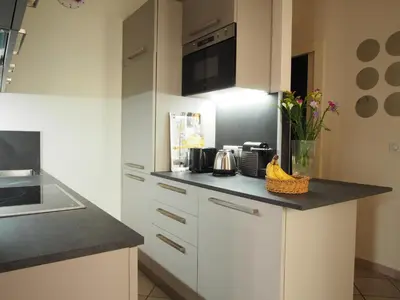 a kitchen with white cabinets and a black counter top at Nice Centre - Apartment with balcony and stunning sea view! in Nice