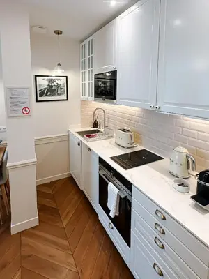 a white kitchen with white cabinets and a sink at Azur Verdun in Nice