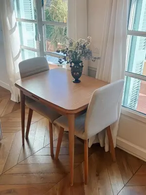 a wooden table with two chairs and a vase with flowers at Azur Verdun in Nice
