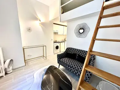 a living room with a ladder and a couch at Studio close to Main Street and Train Station in Nice