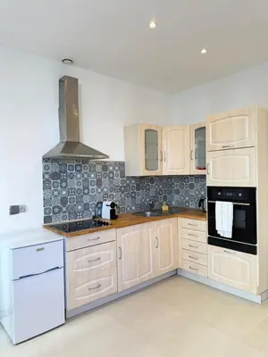 a kitchen with white cabinets and a table in it at Plein centre clim, proche gare et tramway in Nice