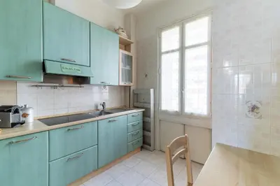 a kitchen with blue cabinets and a sink and a window at HappyFew suite Palazzo in Nice