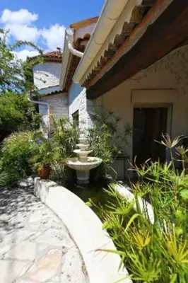 a garden with a fountain in front of a house at Magnifique Villa sur les collines de Nice, 6 Pièces, clim, barbecue, sauna et hammam in Nice