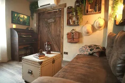 a living room with a couch and a door at Suite des aventuriers - Expérience Unique & Atypique à Nice proche du centre in Nice