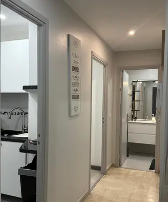 a white kitchen with a sink and a mirror at Appartement Valeria in Saint-Laurent-du-Var