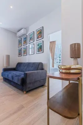 a living room with a blue couch and a table at Magnifique appartement - Jacuzzi - Port de Nice in Nice