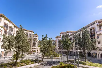 an apartment building with trees in front of it at Magnifique appartement - Jacuzzi - Port de Nice in Nice