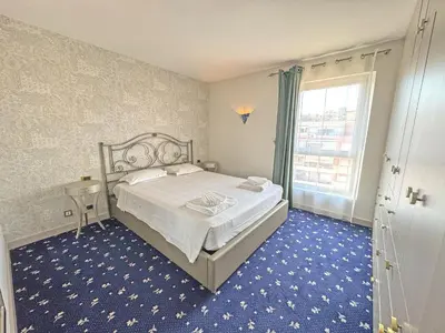 a bedroom with a bed and a large window at Panoramic Pebbles Azur in Nice