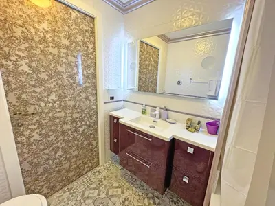 a bathroom with a sink and a shower with a mirror at Panoramic Pebbles Azur in Nice